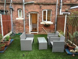a patio with chairs and a table on the grass at Countryside townhouse 