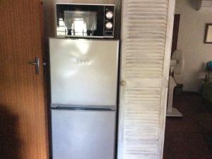 a refrigerator with a microwave on top of it at Swartwitpens 2362 in Marloth Park