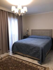 a bedroom with a blue bed and a chandelier at Diklo beach rooms-Adults Only in Zadar