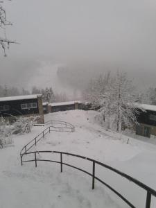 un campo coperto da neve con panchine e un edificio di Terrasses de Malmedy - Duplex 419 a Malmedy