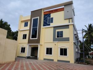 a yellow and white building with a lot of windows at Hotel Wins in Kanyakumari