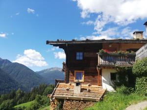 a house in the mountains with a balcony at Appartements Mitteregghaus in Ultimo