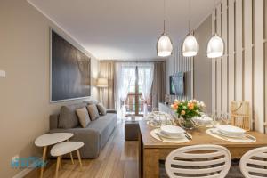 ein Wohnzimmer mit Tisch und Couch in der Unterkunft Apartamenty BlueSky - Przemysłowa, w spokojnej, zielonej okolicy, blisko dworca PKP i sklepów in Karpacz