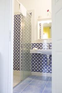 y baño con azulejos azules y blancos y lavabo. en B&B Il Cavaliere Tropea, en Santa Domenica
