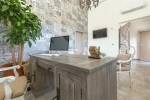 a room with a wooden desk with a tv on a wall at B&B Le Radici del Salento Luxury Rooms in San Pancrazio Salentino