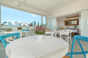 a dining room with a white table and chairs at B&B Le Radici del Salento Luxury Rooms in San Pancrazio Salentino +26 photos