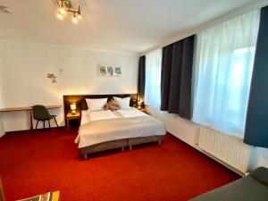ヴェルグルにあるBed & Rooms, Wörglのベッドルーム1室(白いベッド1台、赤いカーペット付)