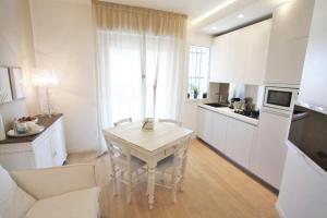 a white kitchen with a table in a room at Pineta Suite in Cervia