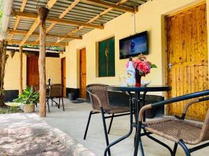 a patio with a table and chairs and a tv at Tradewinds Lodge in Diani Beach