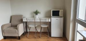 a small table with two chairs and a microwave at Komodor - OZONOWANE pokoje gościnne in Ustronie Morskie