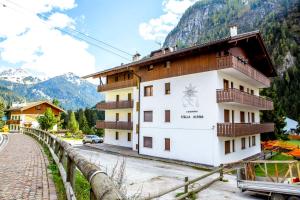 un edificio al lado de una montaña en Majon Viva en Campitello di Fassa