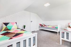 a bedroom with two beds and a white brick wall at Przystań 44 in Świnoujście