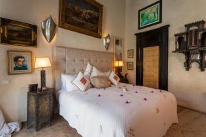Le Palais Rhoul and Spa في مراكش: غرفة نوم بها سرير كبير وعليه زهور