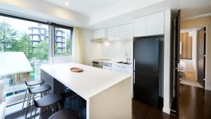 a kitchen with a white counter and a black refrigerator at Kizuna in Kutchan