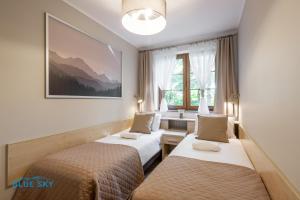 a hotel room with two beds and a picture on the wall at Apartamenty BlueSky - Przemysłowa in Karpacz