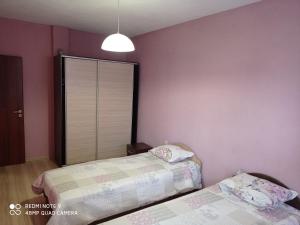 サンダンスキにあるIdeal Center Apartmentのピンクの壁のベッドルーム1室(ベッド2台付)