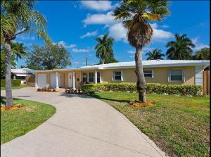 a house with a palm tree and a sidewalk at Beachway Per ankh (House of Life) in Pompano Beach