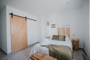 1 dormitorio con 1 cama y puerta corredera en Casa Rural El Aceitunero, en San Vicente de Arévalo