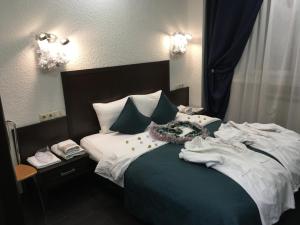 1 dormitorio con 1 cama con sábanas blancas y almohadas azules en Nab Hotel Taganskaya en Moscú