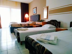 a hotel room with three beds with towels on them at Villa Marija Ulcinj in Ulcinj