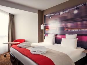 Habitación de hotel con cama y silla roja en Mercure Paris Boulogne, en Boulogne-Billancourt