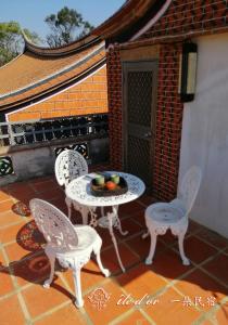 a table and chairs with a bowl of fruit on a patio at île d'or 一朵民宿 - 中蘭 in Jinsha