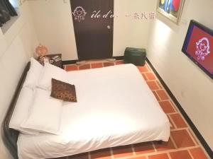 łóżko z białą pościelą i poduszkami w pokoju w obiekcie île d'or 一朵民宿 - 中蘭 w mieście Jinsha