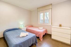 a bedroom with two beds and a window at Hauzify I Apartament Edelweiss in Platja  d'Aro +10 photos