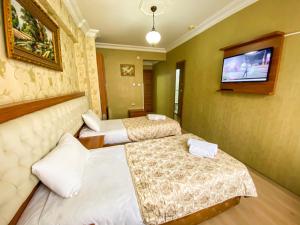 イスタンブールにあるMekke Hotel Istanbulのベッド2台、薄型テレビが備わるホテルルームです。