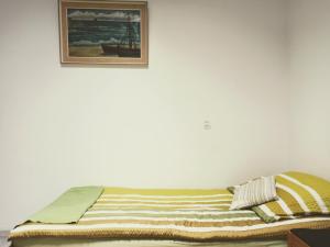 Bett in einem Zimmer mit einem Bild an der Wand in der Unterkunft Kwatery w Gołdapi in Goldap