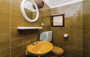 a bathroom with a yellow sink and a mirror at Guest House Tanja in Babino Polje
