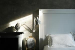 - une chambre avec un lit, une lampe et un miroir dans l'établissement Palazzo Albricci Peregrini, à Côme