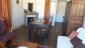 a dining room with a table and a fireplace at appartement "les goumis" in Baccarat