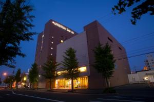 un gran edificio con luces encendidas por la noche en Apple Palace Aomori, en Aomori