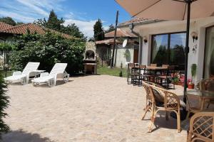 a patio with chairs and a table and an umbrella at Guesthouse Oasis-Shabla in Shabla