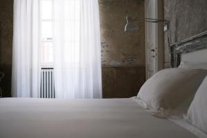 Postel nebo postele na pokoji v ubytování Palazzo Albricci Peregrini