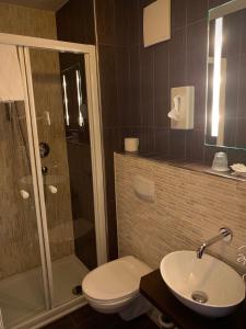ein Bad mit einem WC, einem Waschbecken und einer Dusche in der Unterkunft Hotel Augsburg Langemarck in Augsburg