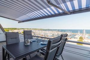 - Balcón con mesa y sillas y vistas al puerto en Ferienwohnung Pier 1167, en Schilksee