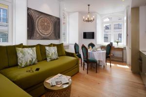 a living room with a green couch and a table at Once Upon Lisboa Family Units in Lisbon