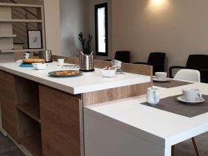 un bancone bianco con un piatto di cibo sopra di B&B Juniperus a SantʼAnna Arresi Altre 30 foto