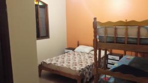 a bedroom with two bunk beds and a mirror at Casa em Peruibe 3 dormitórios sendo 1 suite in Peruíbe