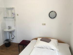 a bedroom with a bed and a sink and a mirror at Hotel Pension Schmellergarten in Munich