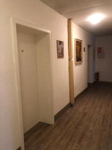 an empty room with a hallway with a door and wood floors at Hotel Pension Schmellergarten in Munich