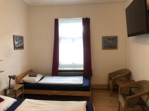 a room with two beds and a window at Hotel Pension Schmellergarten in Munich