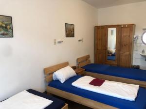 two beds in a room with blue and white at Hotel Pension Schmellergarten in Munich