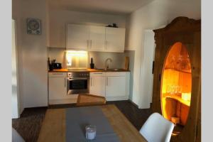 a kitchen with white cabinets and a sink and a table at Ferienwohnung Hildegard in Grefrath