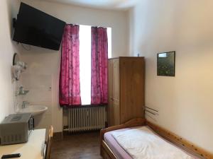 a bedroom with a bed and a sink and a window at Hotel Pension Schmellergarten in Munich