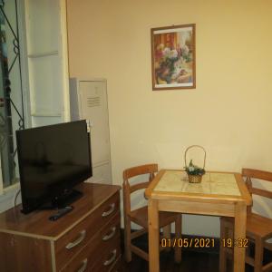 una sala de estar con TV en un tocador y una mesa con una pequeña en Hostal El Rincon Marino, en Valparaíso