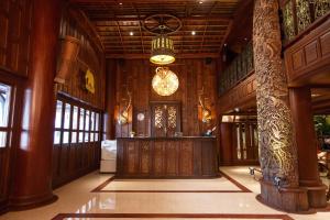 a lobby with wooden walls and a chandelier at Chang Siam Inn in Bangkok