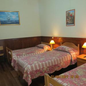 Habitación de hotel con 2 camas y 2 lámparas en Hostal El Rincon Marino, en Valparaíso